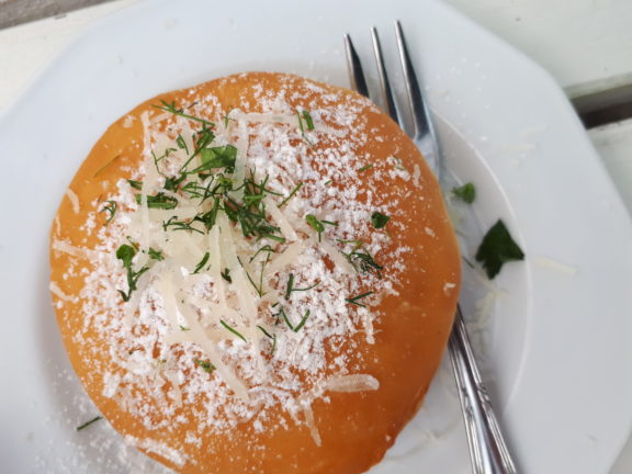 Na zdjęciu pączek z wątróbką posypany parmezanem